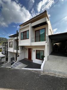 a white house with a lot of windows at Patong Relax Home in Patong Beach