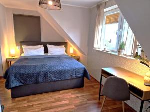 a bedroom with a bed and a desk and a window at Ferienhaus Seerose - Sauna, eingezäunter Garten, Hunde, 3 min zum See in Göhren-Lebbin
