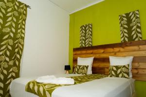 two beds in a room with green walls at Résidence-PKLV in Dzaoudzi