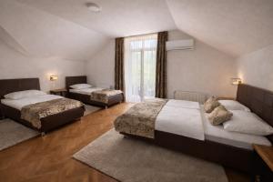 a bedroom with two beds and a window at Motel Marić in Žepče