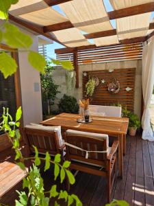 an outdoor patio with a wooden table and chairs at Vila Nainer in Pag
