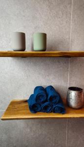 ein Holzregal mit zwei Tassen und einem blauen Handtuch in der Unterkunft Panorama Studio - Sauna, Lakeview & Fireplace in Skaveröd