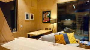 ein Wohnzimmer mit einem Stuhl, einem Tisch und einem Fenster in der Unterkunft Panorama Studio - Sauna, Lakeview & Fireplace in Skaveröd