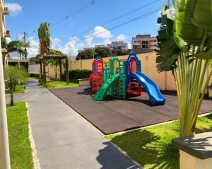 a playground with a slide in a yard at Apto mobiliado 7min da Orla de Atalaia e 1min do Aeroporto in Aracaju