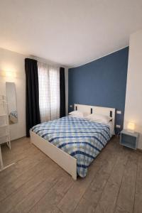a bedroom with a bed with a blue wall at Bilocale tranquillo e funzionale, ideale per soggiorni di lavoro in Vignola