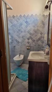 a bathroom with a sink and a tub and a toilet at CASA MUGHETTO R5055 WiFi, seafront, private sea access, swimming pool in La Maddalena