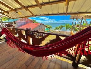 a hammock on a deck with a view of the beach at La Bamba in Termales - agua caliente - nuqui