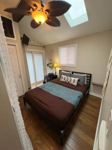 a bedroom with a bed with a ceiling fan at Sunset Cove AC Waterfront Kayaks in Tobermory
