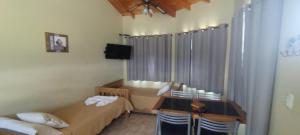 a small room with two beds and a table at Cabañas Altos del Nagual in Valle Hermoso
