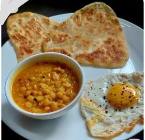 a plate of breakfast food with eggs and toast at The Lodge Inn in Karachi