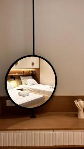 a circular mirror in a bedroom with a bed at Luxurios seaside apartment 2 in Durrës