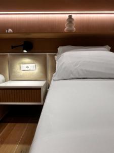 a close up of a bed with a nightstand and a bed sidx sidx sidx at Luxurios seaside apartment 2 in Durrës