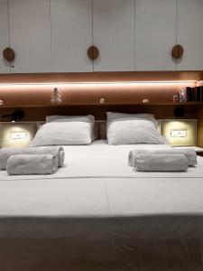 a large bed with two pillows and towels on it at Luxurios seaside apartment 2 in Durrës