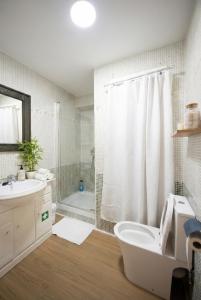 a bathroom with a toilet and a shower and a sink at Apartalux Playa Diva in Grao de Castellón