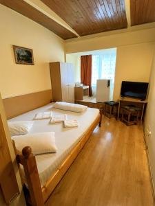 a bedroom with a large bed and a television at Hotel Decebal Bistrita in Bistriţa