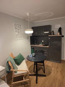 a small living room with a table and a kitchen at Waldfeder Apartment mit Pool und Fitnessraum, neu und vollsaniert in Sankt Englmar