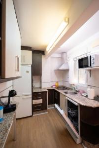 a kitchen with white appliances and wooden floors at Apartalux Playa Diva in Grao de Castellón