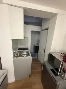 a small kitchen with a sink and a microwave at Le petit Rouennais in Rouen