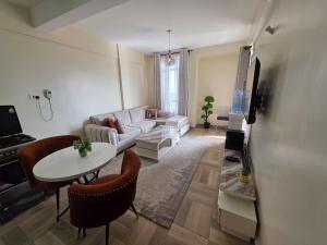 a living room with a couch and a table at Jay Homes - Modern & Cozy Apartments PGS Plaza - Nakuru CBD in Nakuru