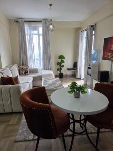 a living room with a white table and chairs at Jay Homes - Modern & Cozy Apartments PGS Plaza - Nakuru CBD in Nakuru
