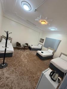 a room with two beds and a table and chairs at SAMA Economic Apartment in Medina
