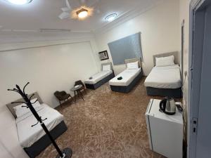 a hotel room with two beds and a couch at SAMA Economic Apartment in Medina