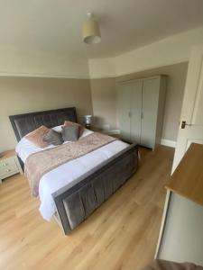 a bedroom with a large bed and a wooden floor at Spacious Dinnington bungalow in Dinnington