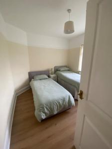 two beds in a small room with a door open at Spacious Dinnington bungalow in Dinnington