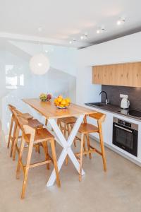 a kitchen with a wooden table and four chairs at Penthouse Villa with Private Pool, Sauna & Seaview in Gialova
