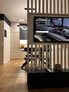 a living room with a desk and a television on a wall at Noir luxury apartment in Durrës