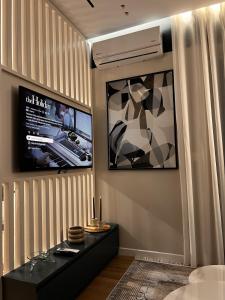 a room with a bed and a tv and a table at Noir luxury apartment in Durrës