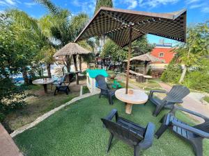 a group of chairs and tables in a yard at Complejo Los Cipreses in Villa Carlos Paz