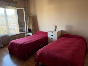 a bedroom with two beds with red blankets and a window at Casa con encanto en Monachil in Monachil +22 photos