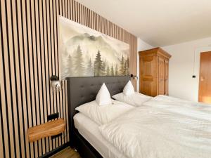 a bedroom with a large bed with a picture on the wall at Hotel Berghof in Hellenthal