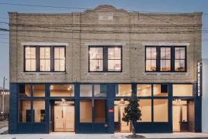 a brick building with large windows on a street at The Harriss in Wilson