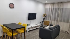 a living room with a table and yellow chairs at Casa Morada in Mindelo