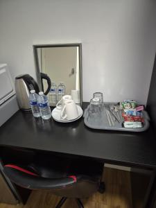 a black desk with a plate and water bottles on it at Comfort Lodge in Nottingham +10 photos