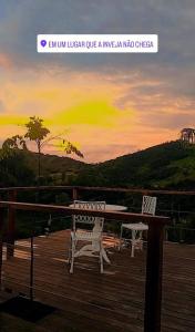 a picture of a table and chairs on a deck at Chácara Pôr do sol in Alfenas
