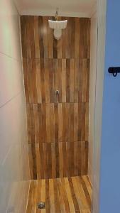 a shower with a wooden wall in a bathroom at Chácara Pôr do sol in Alfenas +33 photos