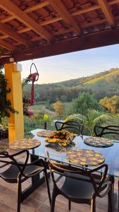 a table and chairs on a patio with a view at Chácara Pôr do sol in Alfenas