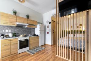 a kitchen with wooden cabinets and a white refrigerator at Studio 35 - Modern & Cozy Studio in Chalandri City Center in Athens