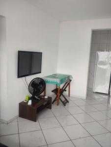 a living room with a table and a flat screen tv at Apto mongagua in Mongaguá