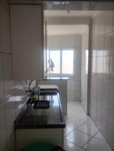a small kitchen with a sink and a window at Apto mongagua in Mongaguá