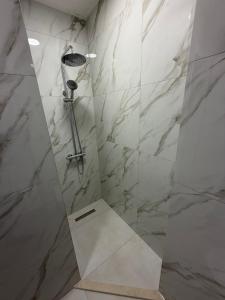 a bathroom with a shower with a glass door at ZONE apartments in Prishtinë +3 photos