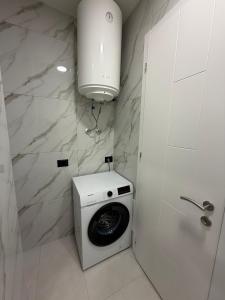 a washer and dryer in a white bathroom at ZONE apartments in Prishtinë