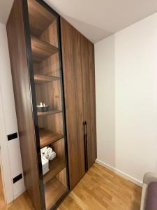 a room with a wooden closet with wooden shelves at ZONE apartments in Prishtinë