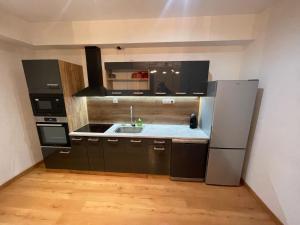 a kitchen with a sink and a refrigerator at L'Idéal in Guillestre