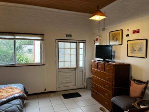 a bedroom with a bed and a tv on a dresser at Casa do Stefan in Lomba