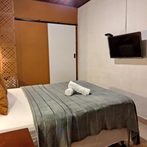 a room with a bed with a tv on the wall at Pousada Schueng in Trindade