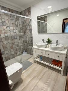 a bathroom with a toilet and two sinks and a shower at Casa Sardine in Santo Isidoro